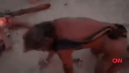 A Man With A Scarf Around His Neck Is Standing In The Desert . GIF