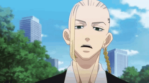 A Man With A Shaved Head And Long Hair Is Standing In Front Of A City Skyline . GIF
