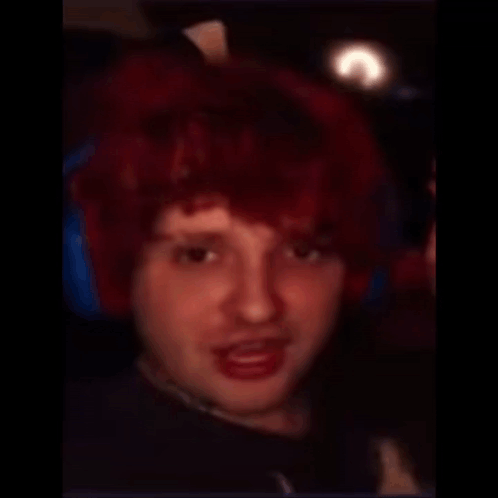 A Man With A Shaved Head And Red Hair Looks At The Camera GIF