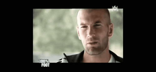 A Man With A Shaved Head Is On A Television Screen With The Words 100 % Foot On It GIF