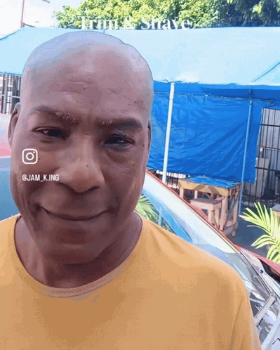 a man with a shaved head is smiling for the camera
