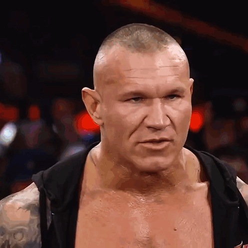 A Man With A Shaved Head Is Wearing A Black Hoodie GIF