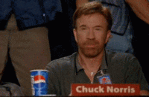 A Man With A Sign That Says Chuck Norris GIF