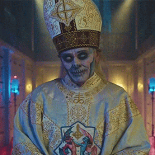 A Man With A Skull Face Painted On His Face Is Wearing A Priest 'S Robe And Hat . GIF