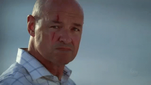 A Man With A Slice Of Orange In His Mouth Looks At The Camera With A Blurred Background That Says Fox GIF