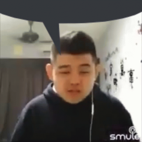 A Man With A Speech Bubble Above His Head Is Wearing Headphones And Looking At The Camera . GIF