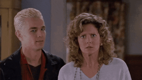 Man With Spike Hair And Curly-Haired Woman GIF