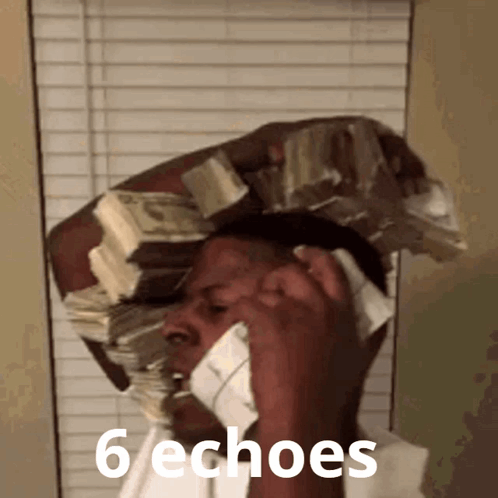 a man with a stack of money on his head talking on a phone