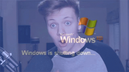 A Man With A Surprised Look On His Face Is Looking At A Screen That Says Windows Is Shutting Down GIF