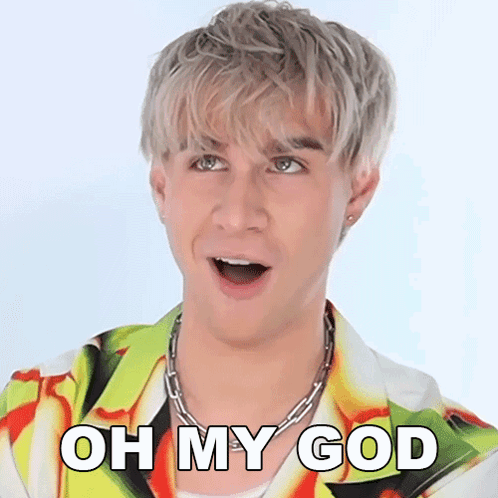 A Man With A Surprised Look On His Face Is Wearing A Colorful Shirt And A Chain Necklace . GIF