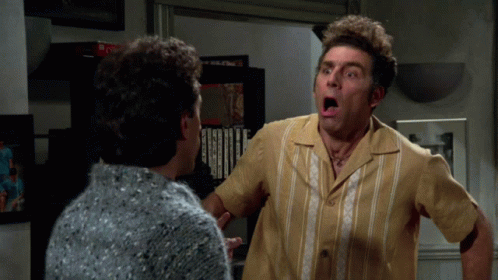 A Man With A Surprised Look On His Face Looks At Another Man GIF