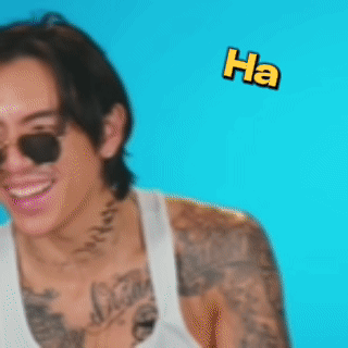 A Man With A Tattoo On His Arm Is Laughing With The Words Ha Flying Around Him GIF