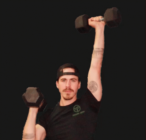 A Man With A Tattoo On His Arm Is Lifting Two Dumbbells Over His Head GIF