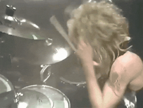 A Man With A Tattoo On His Arm Is Playing A Drum Set GIF