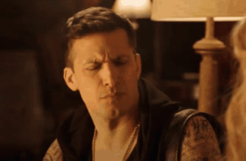 Man With Tattoo Sitting Under Lamp GIF