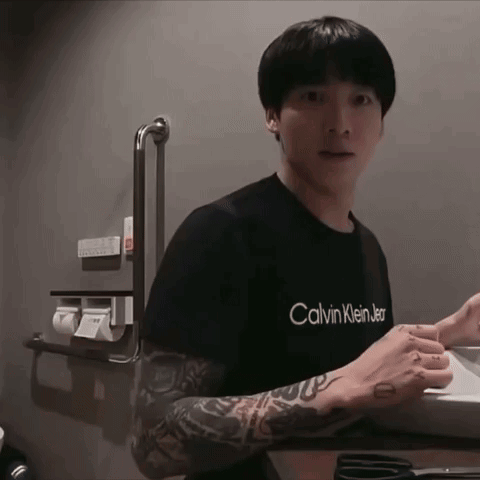A Man With A Tattoo On His Arm Is Wearing A Black Calvin Klein Shirt GIF