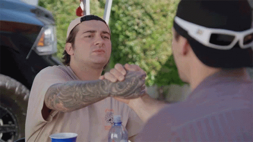 Man With Tattoo Shakes Hands With Another Man GIF