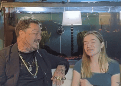 A Man With A Tattoo On His Arm Talks To A Girl GIF