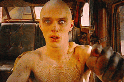 A Man With A Tattoo On His Chest Is Pointing GIF
