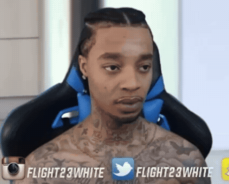 A Man With A Tattoo On His Chest Is Sitting In A Chair With Flight23white Written On The Bottom Right GIF