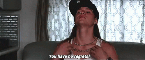 A Man With A Tattoo On His Chest Is Sitting On A Couch And Asking If He Has No Regrets . GIF