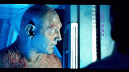 A Man With A Tattoo On His Chest Looks At Another Man With The Name Cravello2021 On The Bottom GIF
