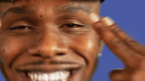 A Man With A Tattoo On His Forehead Is Smiling And Pointing At His Face GIF