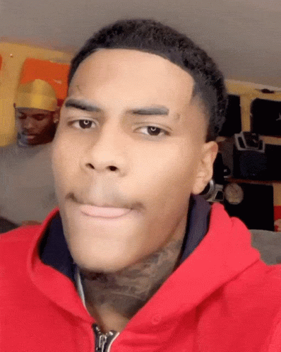 A Man With A Tattoo On His Forehead Wears A Red Jacket GIF