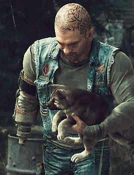 A Man With A Tattoo On His Head Is Holding A Dog GIF