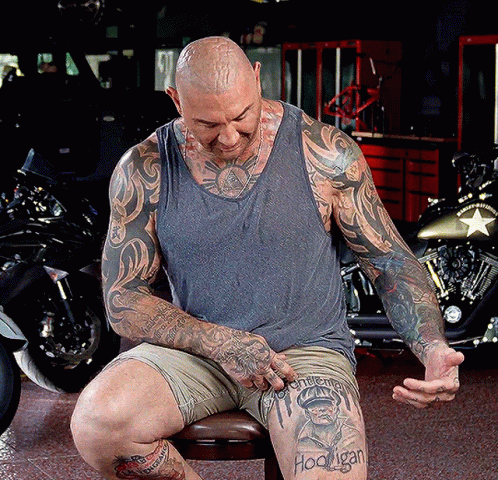 A Man With A Tattoo On His Leg That Says ' Hoonigan ' GIF