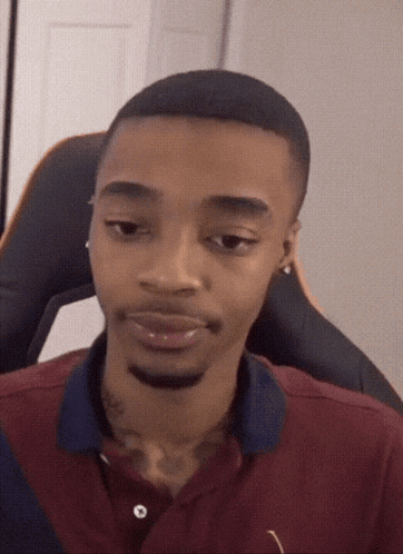A Man With A Tattoo On His Neck Is Wearing A Maroon Shirt GIF