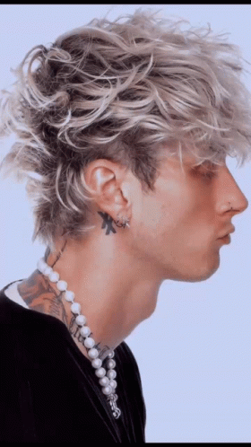 A Man With A Tattoo On His Neck Wearing Pearls And Earrings GIF