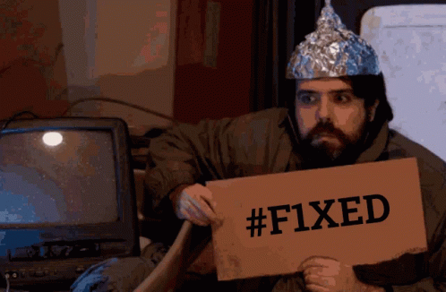 A Man With A Tin Foil Hat Is Holding A Sign That Says # F1xed GIF