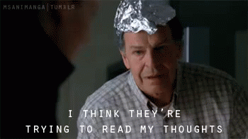 A Man With A Tin Foil Hat On His Head Says I Think They 'Re Trying To Read My Thoughts GIF