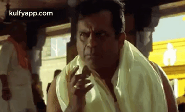 A Man With A Towel Around His Neck Is Making A Funny Face While Standing In Front Of A Crowd . GIF
