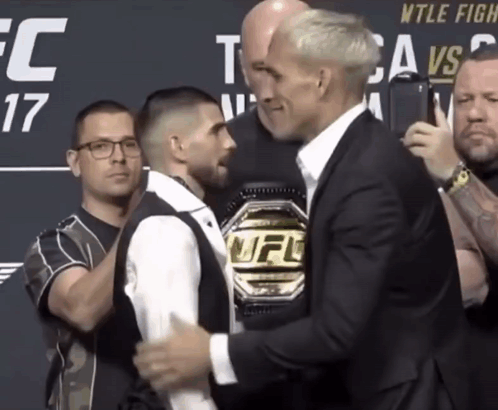 A Man With A Ufc Belt Stands Next To Another Man GIF