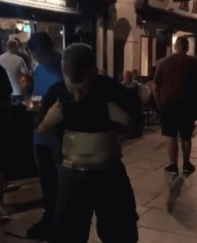 A Man With A Very Large Belly Is Standing In A Crowd GIF