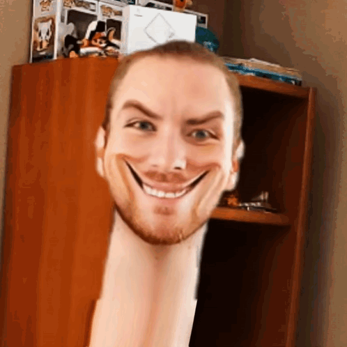 A Man With A Very Long Neck Is Smiling In Front Of A Bookshelf . GIF