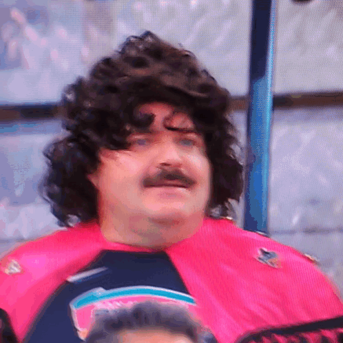 A Man With A Wig And Mustache Is Wearing A Pink Shirt That Says Sharks GIF