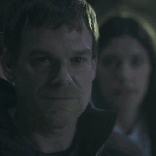 A Man With A Woman In The Background And The Words You Smug Fuck GIF
