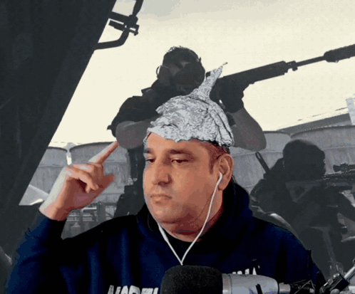 A Man With Aluminum Foil On His Head Is Wearing Headphones And A Hoodie That Says ' Nadel ' On It GIF