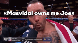 A Man With An American Flag Wrapped Around His Chest Is Being Interviewed By Colby Covington GIF