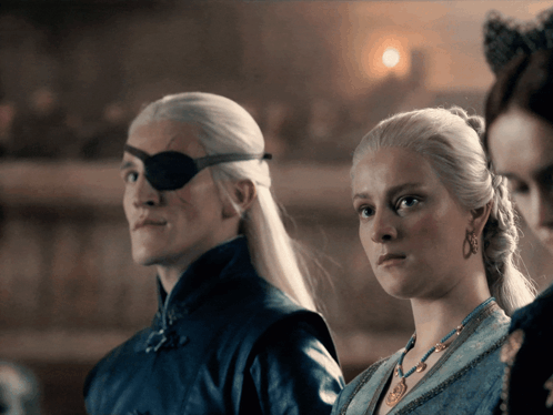 A Man With An Eye Patch And A Woman In A Blue Dress GIF
