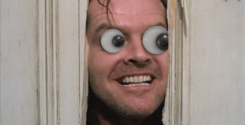 A Man With Big Eyes Looks Through A Hole In A Door With The Words Here 'S Johnny Written On It GIF