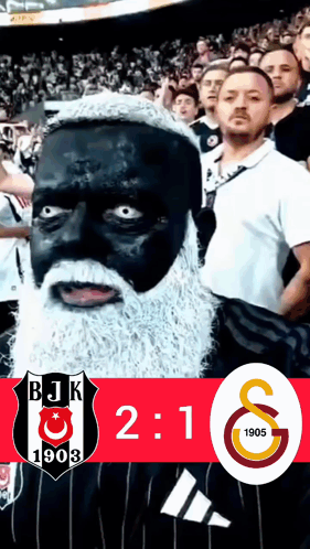 A Man With Black Paint On His Face And A White Beard Stands In Front Of A Bjk 1903 Logo GIF