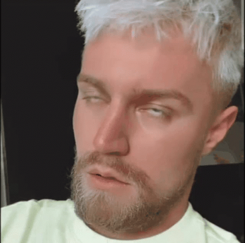 a man with blonde hair and a beard is making a funny face .
