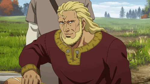 A Man With Blonde Hair And A Beard Wears A Red Shirt With Gold Trim GIF