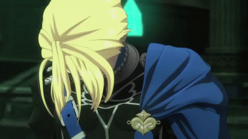 A Man With Blonde Hair And A Blue Cape Looks Down GIF