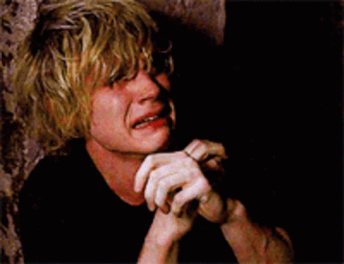 A Man With Blonde Hair Is Crying With His Hands On His Chin GIF