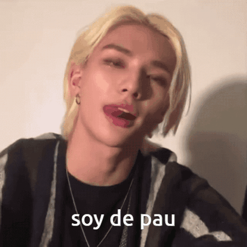 A Man With Blonde Hair Is Sticking His Tongue Out And The Words Soy De Pau Are Visible GIF